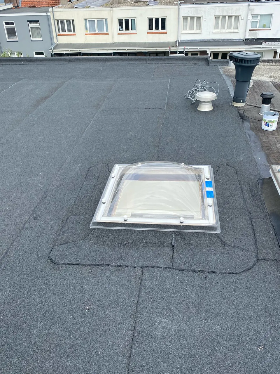 Plat dak met bitumen dakbedekking en lichtkoepel