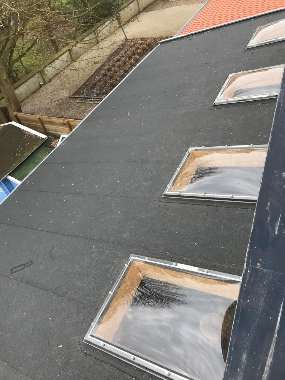 Plat dak met bitumen dakbedekking en lichtkoepels