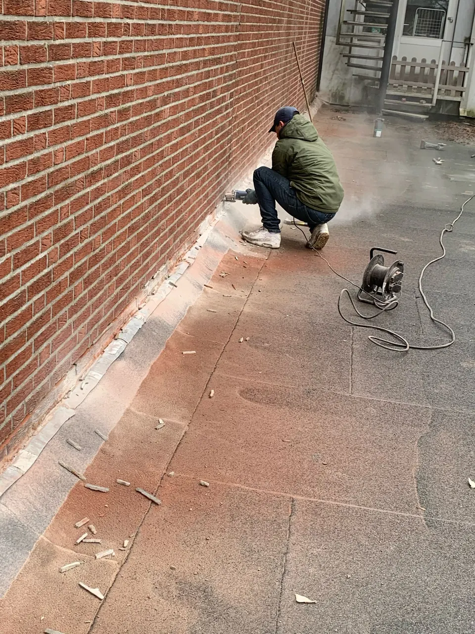 Dakdekker aan het werk bij een muuraansluiting